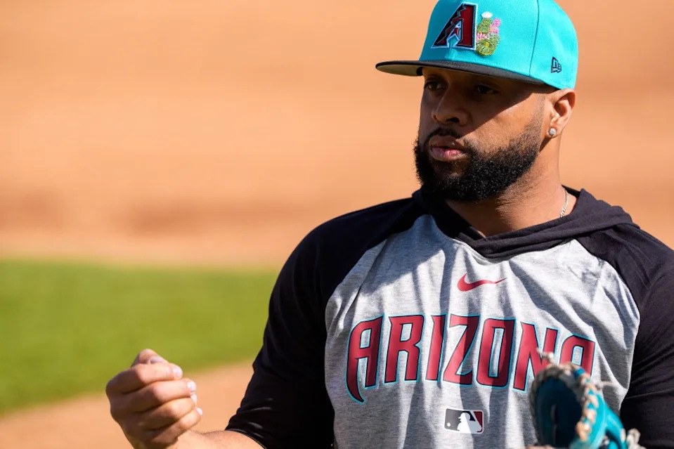 Diamondbacks infielder Carlos Santana warms up for workouts at Salt River Fields at Talking Stick. Allan Henry-Imagn Images