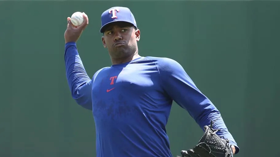 Texas Rangers pitcher Kumar Rocker throws in a blue practice T-shirt before a game. 