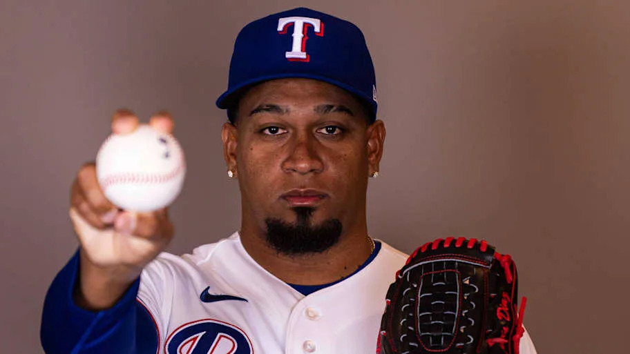 Texas Rangers pitcher Alexis Diaz poses for the camera while holding a baseball. 
