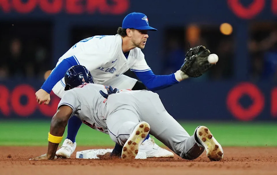 Houston Astros outfielder Jesús Sánchez (front) slides back to second base safely on a pick-off attempt ahead of the tag from Toronto Blue Jays shortstop Ernie Clement (22) during second inning MLB baseball action in Toronto on Wednesday, September 10, 2025. THE CANADIAN PRESS/Nathan Denette