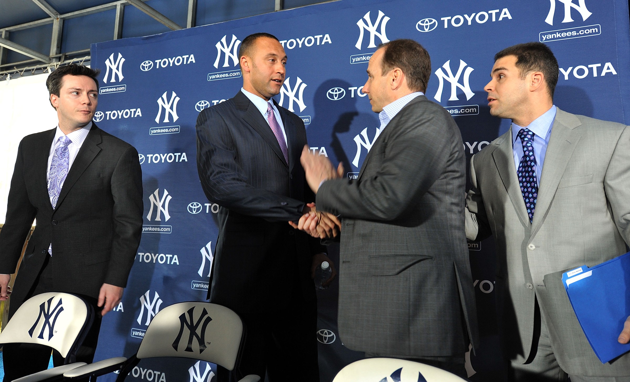 TAMPA, FL - DECEMBER 07: Shortstop Derek Jeter of the New York Yankees (2L) shakes hands with General Manager Brian Cashman (2R) during a press conference to announce his new contract with the club on December 7, 2010 in Tampa, Florida. (Photo by Tim Boyles/Getty Images)