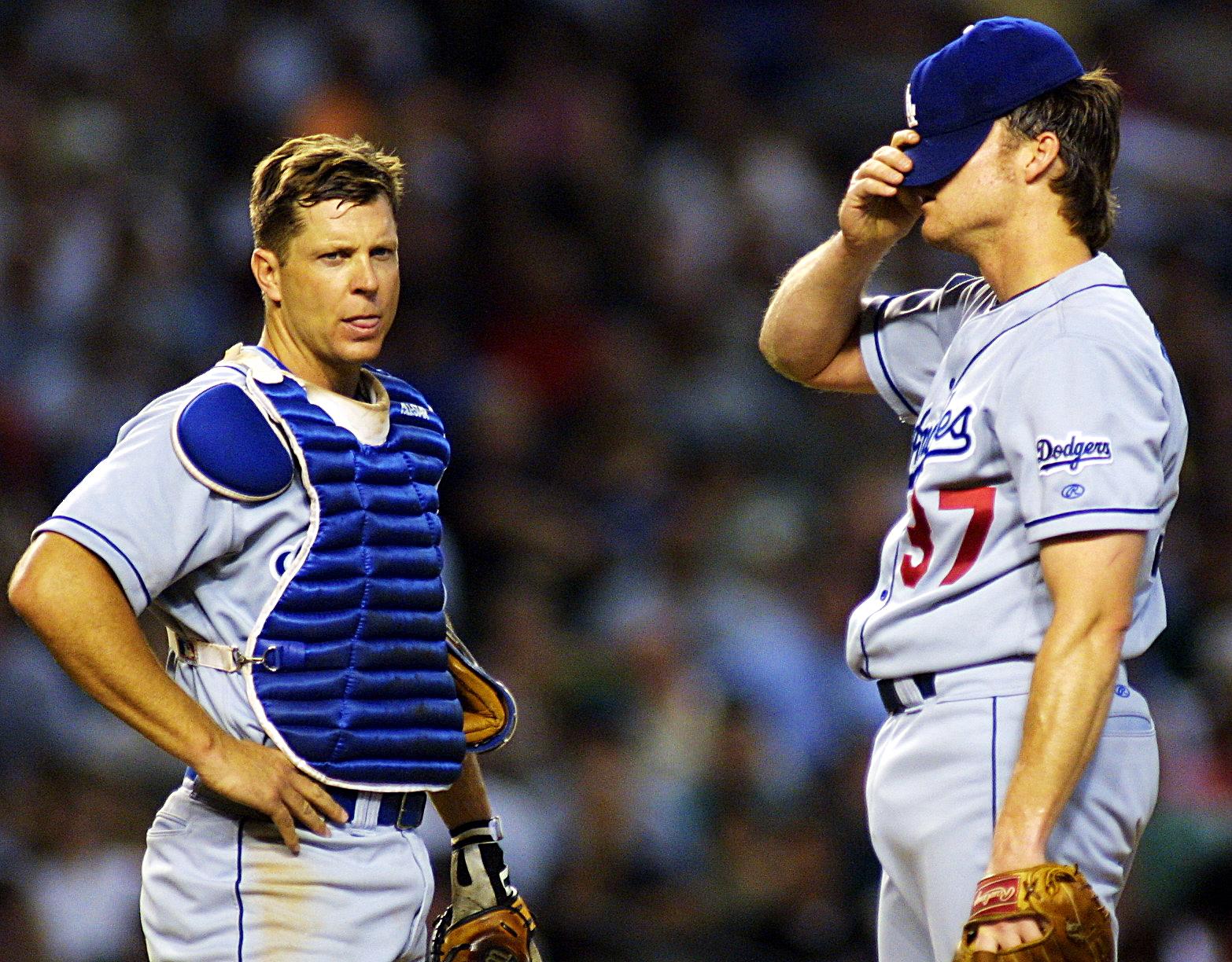 Los Angeles Dodgers starting pitcher Darren Dreifort (R) adjusts his cap while speaking with catcher Chad Kreuter on the mound after he walked Arizona Diamondbacks’ Junior Spivey during the third inning 07 June 2001 in Phoenix, AZ. The Diamondbacks won 13-9. AFP Photo/Mike FIALA (Photo by Mike FIALA / AFP) (Photo credit should read MIKE FIALA/AFP via Getty Images)