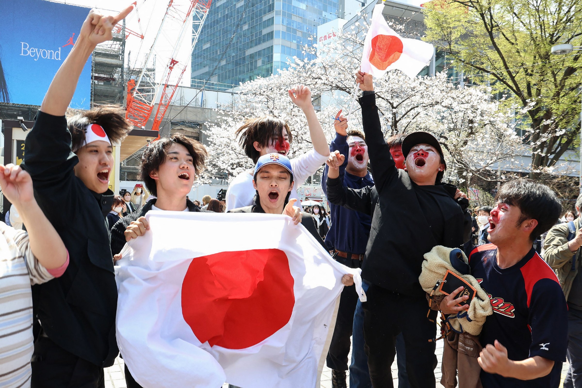 Supporters of Japan’s national baseball team cheer outside Shibuya Station in Tokyo on March 22, 2023, after Japan beat the US 3-2 in the final of the World Baseball Classic (WBC) in Miami to take the championship for a record third time. (Photo by JIJI Press / AFP) / Japan OUT (Photo by STR/JIJI Press/AFP via Getty Images)