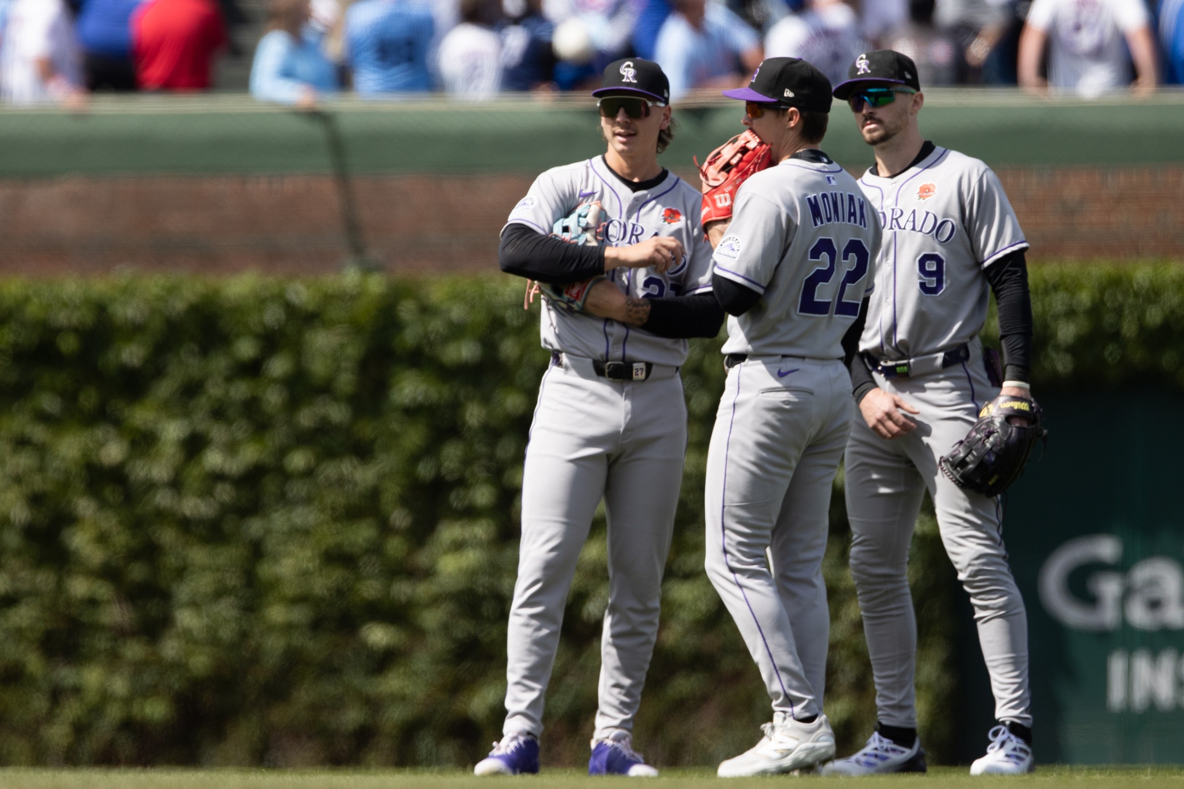 CHICAGO, IL - MAY 26: Jordan Beck #27, Mickey Moniak #22 and Brenton Doyle #9 of the Colorado Rockies talk in the seventh inning during the game between the Colorado Rockies and the Chicago Cubs at Wrigley Field on Monday, May 26, 2025 in Chicago, Illinois. (Photo by Griffin Quinn/MLB Photos via Getty Images)
