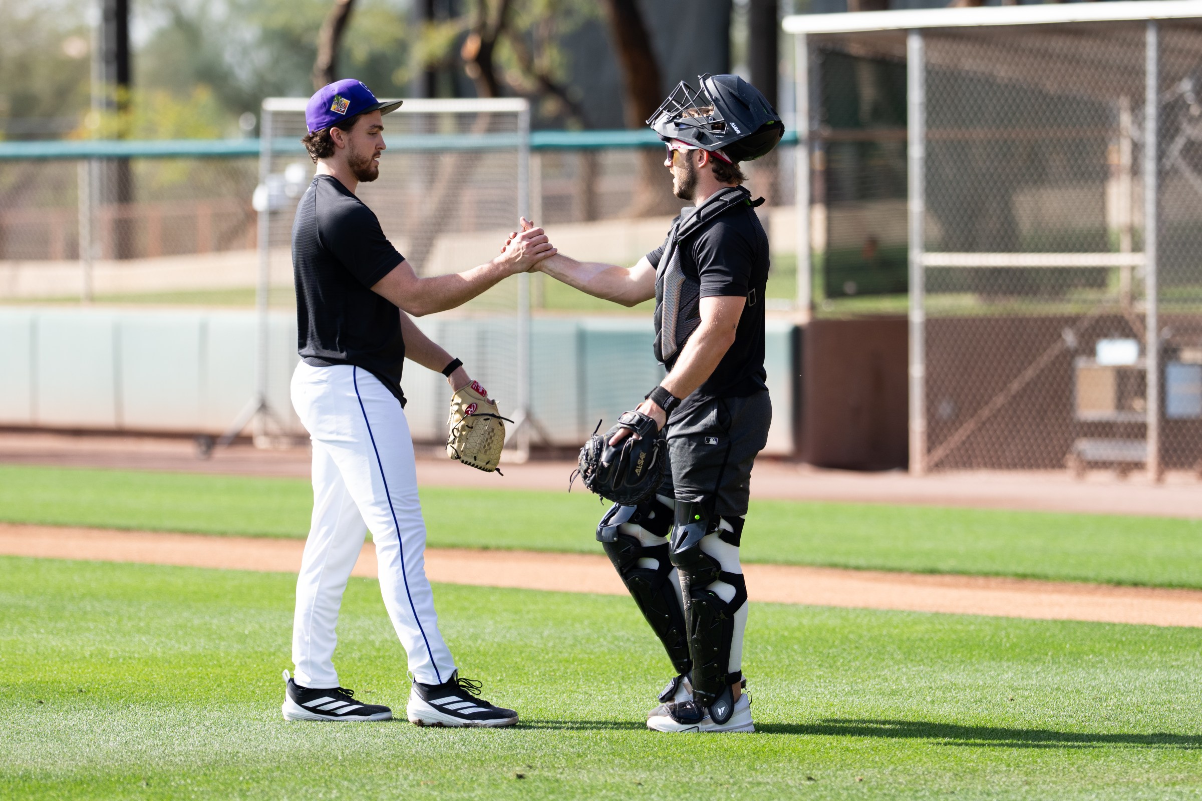 SCOTTSDALE, ARIZONA - FEBRUARY 10: Chase Dollander #32 of the Colorado Rockies shakes hands with catcher Braxton Fulford #37 at Salt River Fields at Talking Stick on February 10, 2026 in Scottsdale, Arizona. (Photo by Kyle Cooper/Colorado Rockies/Getty Images)