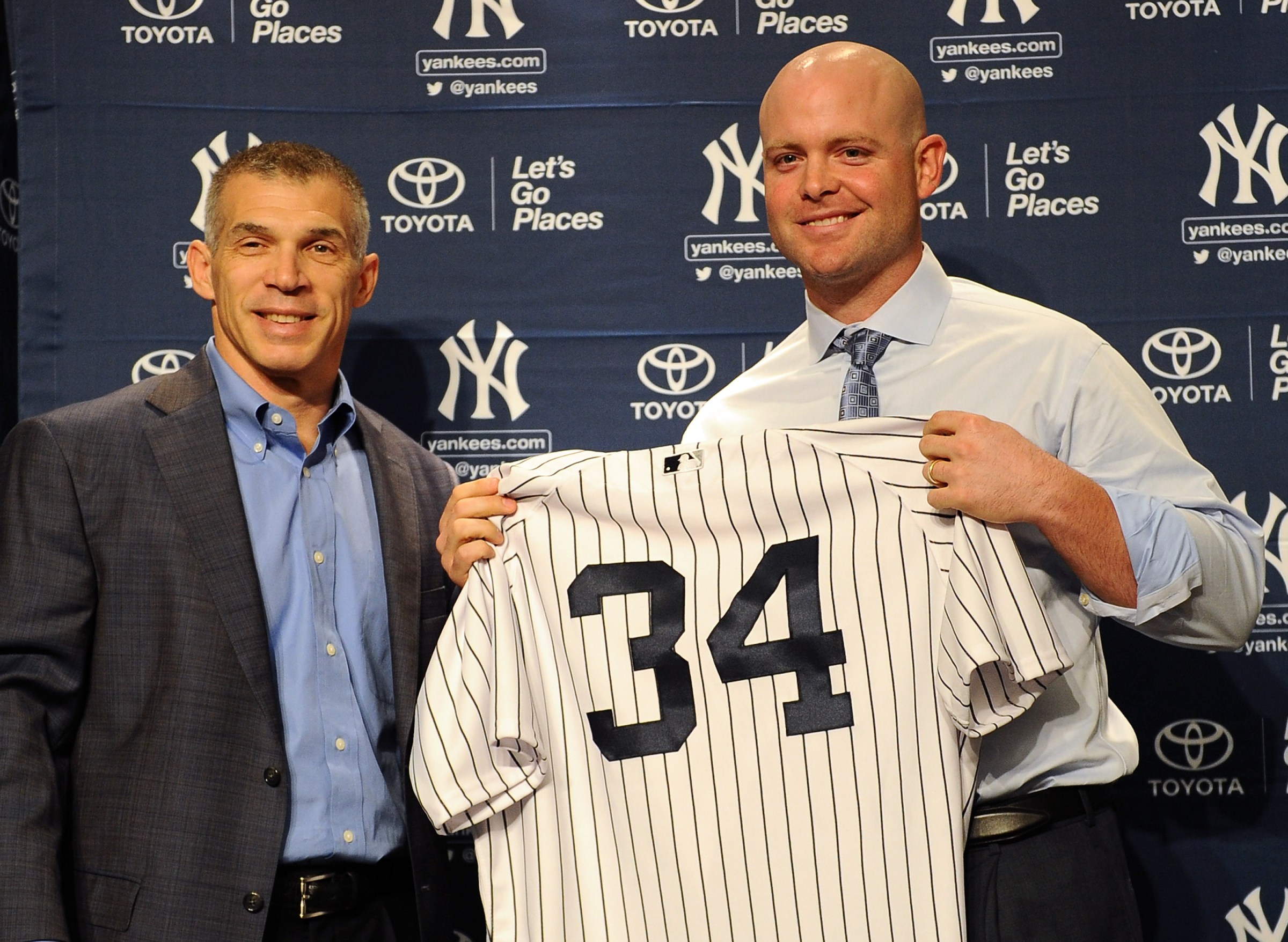 NEW YORK, NY - DECEMBER 05: New York Yankees head coach Joe Girardi presents catcher Brian McCann with his jersey during his introductory press conference at Yankee Stadium on December 5, 2013 in the Bronx borough of New York City. (Photo by Maddie Meyer/Getty Images)