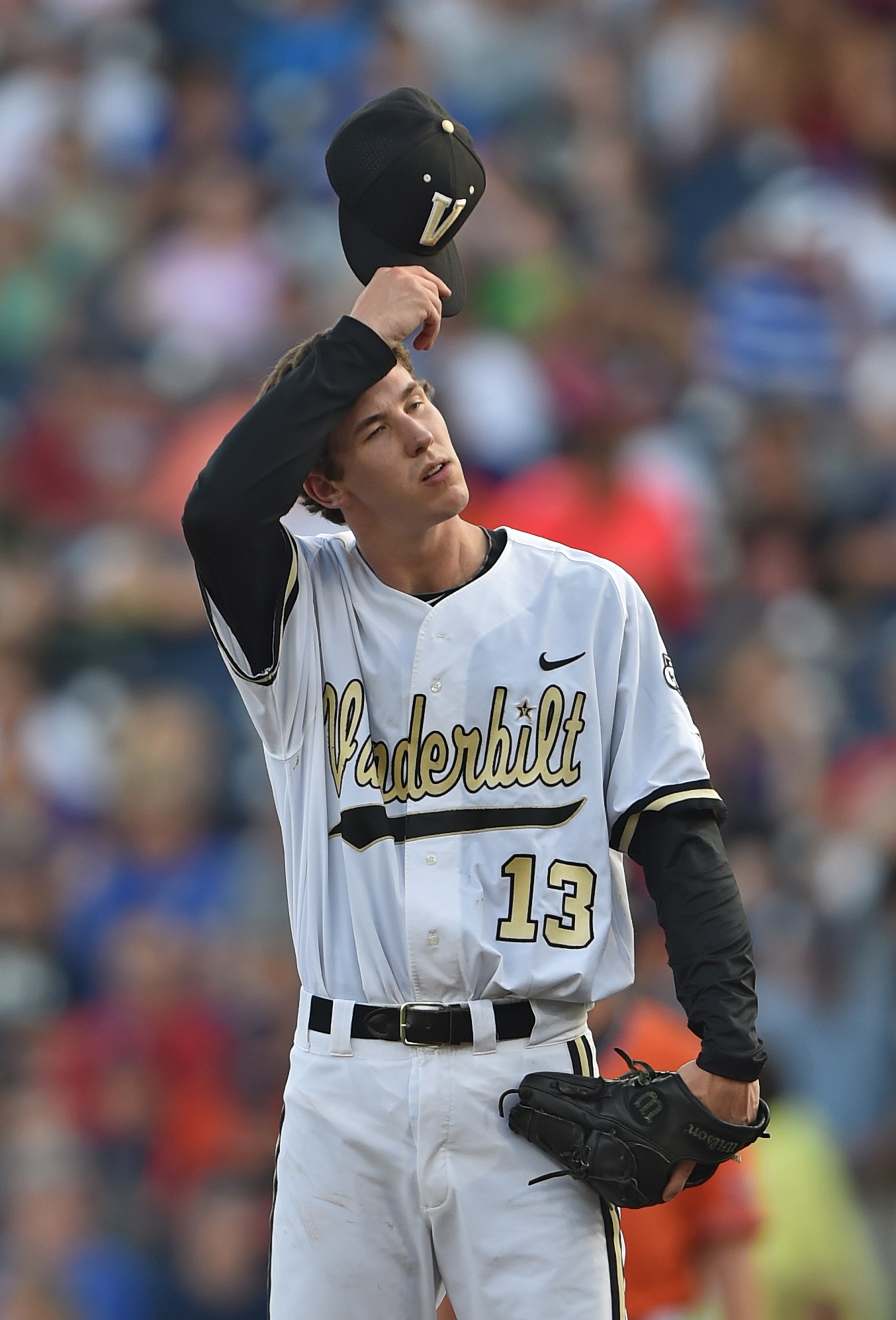 OMAHA, NE - JUNE 24 Pitcher Walker Buehler #13 of the Vanderbilt Commodores wipes his forehead, as he faces the bases loaded against the Virginia Cavaliers in the first inning during game three of the College World Series Championship Series on June 24, 2015 at TD Ameritrade Park in Omaha, Nebraska. (Photo by Peter Aiken/Getty Images)