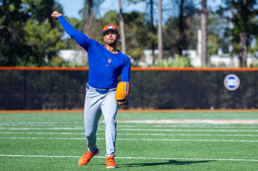 New York Mets pitcher Freddy Peralta throwing a baseball during spring training.