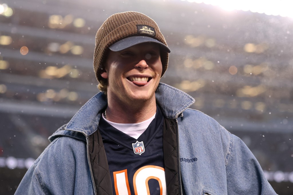 Pete Crow-Armstrong wearing a Chicago Bears jersey, smiling, with snow falling around him.