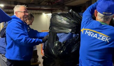 Amelung and another mover wrap a X-ray machine with padding before loading it onto a truck.