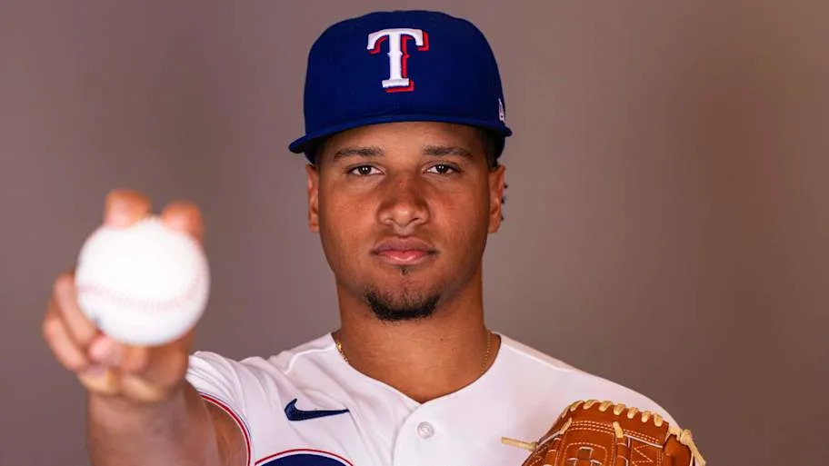 Texas Rangers pitcher Leandro Lopez holds a baseball for the camera.