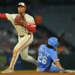 Kansas City Royals second baseman Adam Frazier (26) is out as Los Angeles Angels second baseman Christian Moore (4) throws to first for a double play in the eighth inning at Angel Stadium.