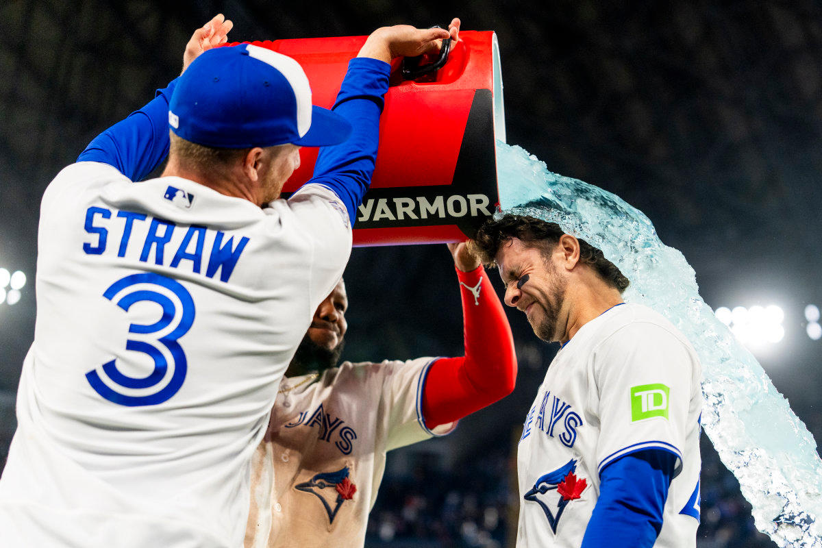 Toronto Blue Jays center fielder Myles Straw, first baseman Vladimir Guerrero Jr. (center) and third baseman Ernie Clement celebrate a win.© Kevin Sousa-Imagn Images