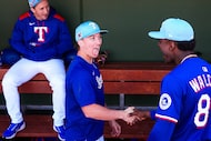 Texas Rangers infielder Cam Cauley shakes hands with infielder Sebastian Walcott before a...
