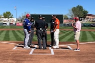 Texas Rangers quality control coach Rod Barajas exchanges lineup cards with umpires, while...