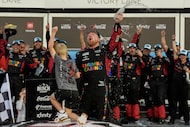 Tyler Reddick, (45) and his son Beau celebrate with the team after winning the NASCAR...