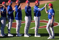 Texas Rangers infielder Cameron Cauley (right) high fives catcher Willie MacIver as players...