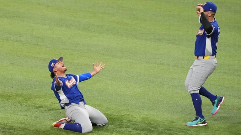 Venezuela pitcher Daniel Palencia, left, celebrates after the team defeated...