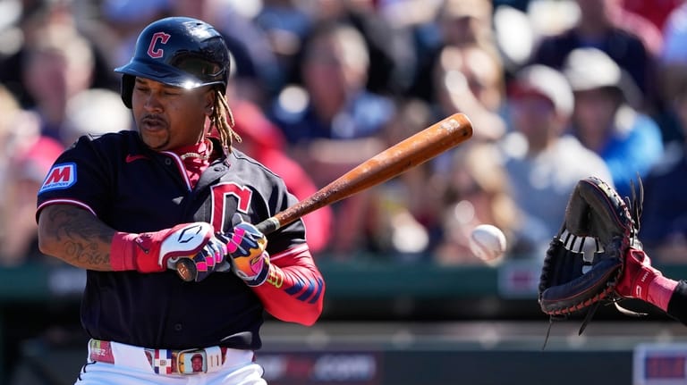 Cleveland Guardians' José Ramírez moves out of the way of...