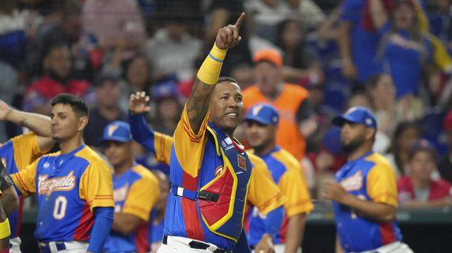 Salvador Perez #13 of Venezuela points towards Eugenio Suarez #7 at first base after Suarez hit an RBI single in the eighth inning against the Dominican Republic at loanDepot park on March 11, 2023 in Miami, Florida.