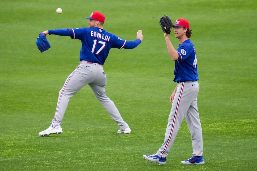 Texas Rangers pitchers Nathan Eovaldi (17) and Jacob Degrom throw in the outfield during a...