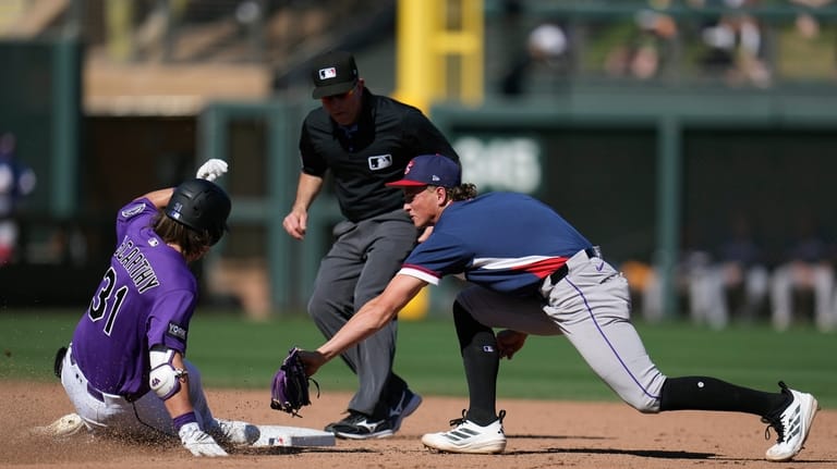 Colorado Rockies' Jake McCarthy (31) slides safely into second base...