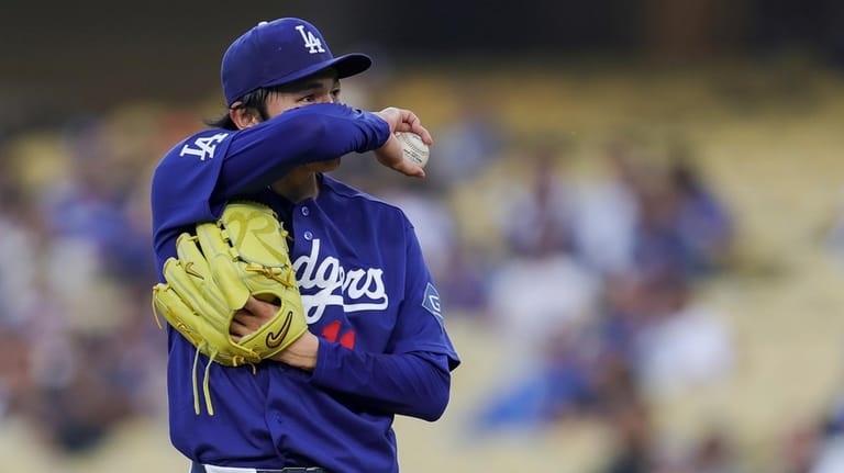 Los Angeles Dodgers starting pitcher Roki Sasaki reacts during the...