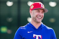 Texas Rangers manager Skip Schumaker laughs while watching pitcher take fielding practice...