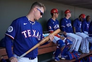 Texas Rangers infielder Joc Pederson pucks up a bat in the dugout during the first inning of...