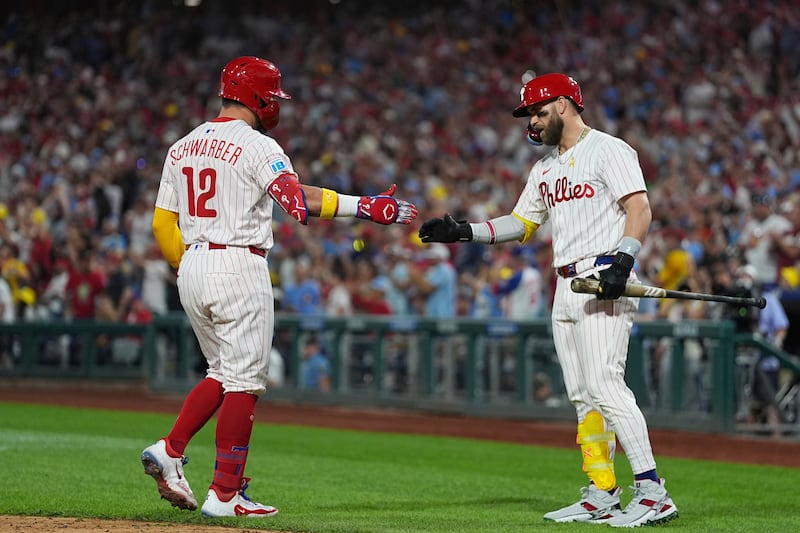 Philadelphia Phillies' Kyle Schwarber, left, celebrates with Bryce Harper after hitting a home run off of Angel Zerpa during the fifth inning of a baseball game, Saturday, Sept. 13, 2025, in Philadelphia. (AP Photo/Matt Rourke)