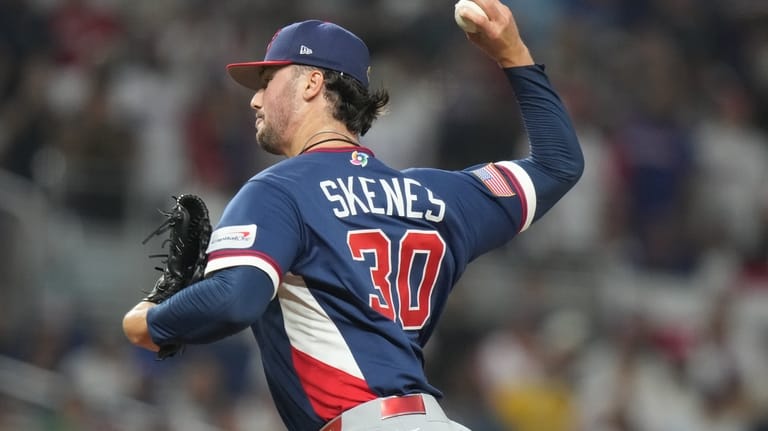 United States pitcher Paul Skenes (30) aims a pitch during...