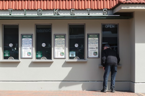 A baseball fan leans into a ticket booth window at Wrigley Field on March 25, 2026. Opening day is Thursday between the Cubs and Nationals. (John J. Kim/Chicago Tribune)