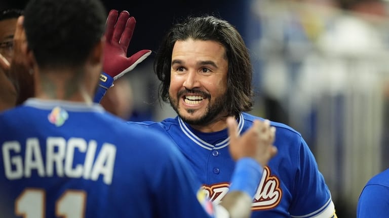 Venezuela designated hitter Eugenio Suárez celebrates after hitting a home...