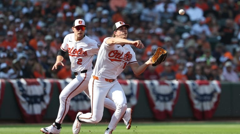 Baltimore Orioles first baseman Coby Mayo throws to second base...