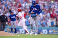 Texas Rangers stating pitcher Nathan Eovaldi, right, reacts to giving up a three-run home...