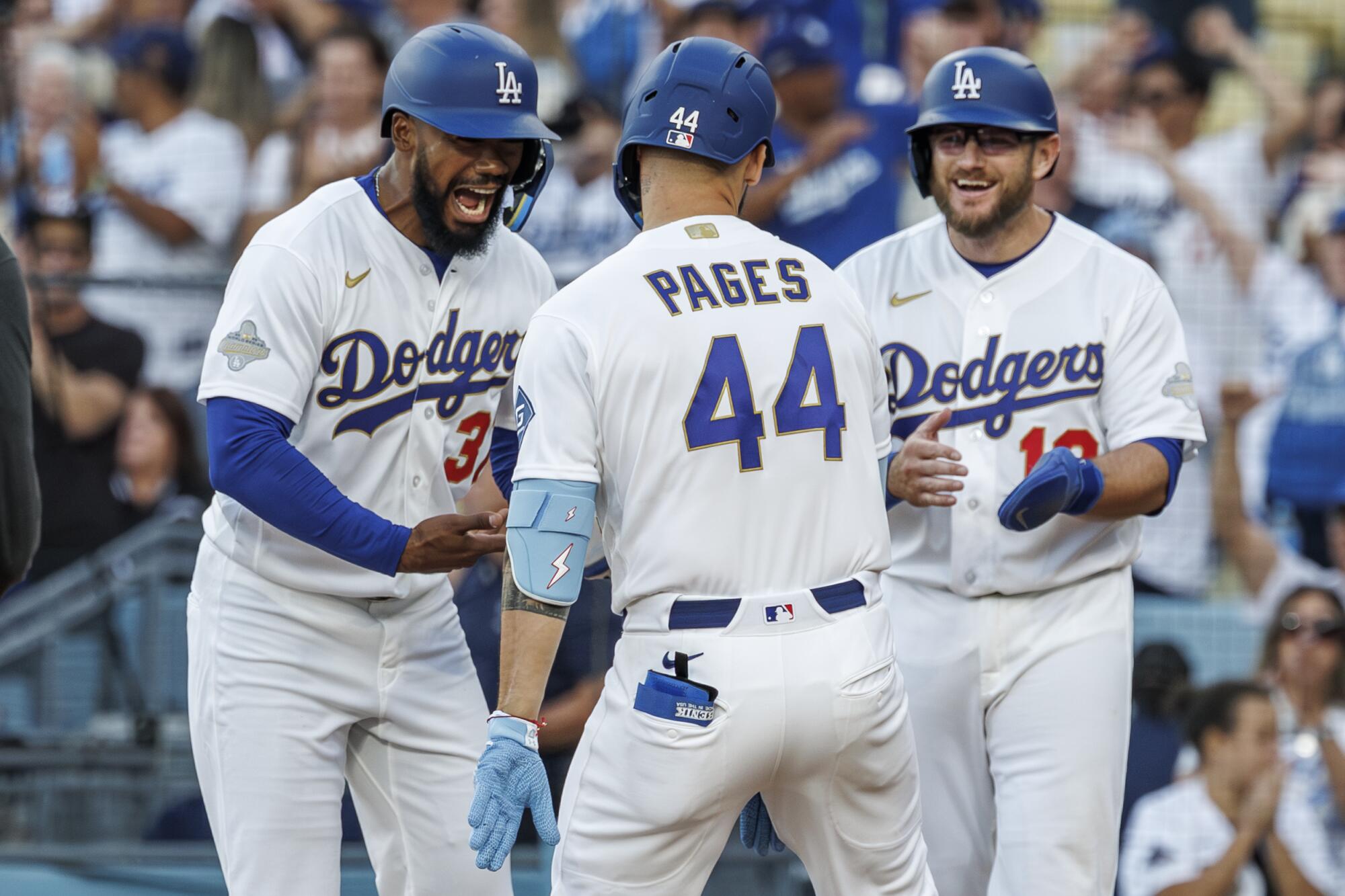 Andy Pages celebrates with Teoscar Hernández and Max Muncy after hitting a home run at Dodger Stadium.