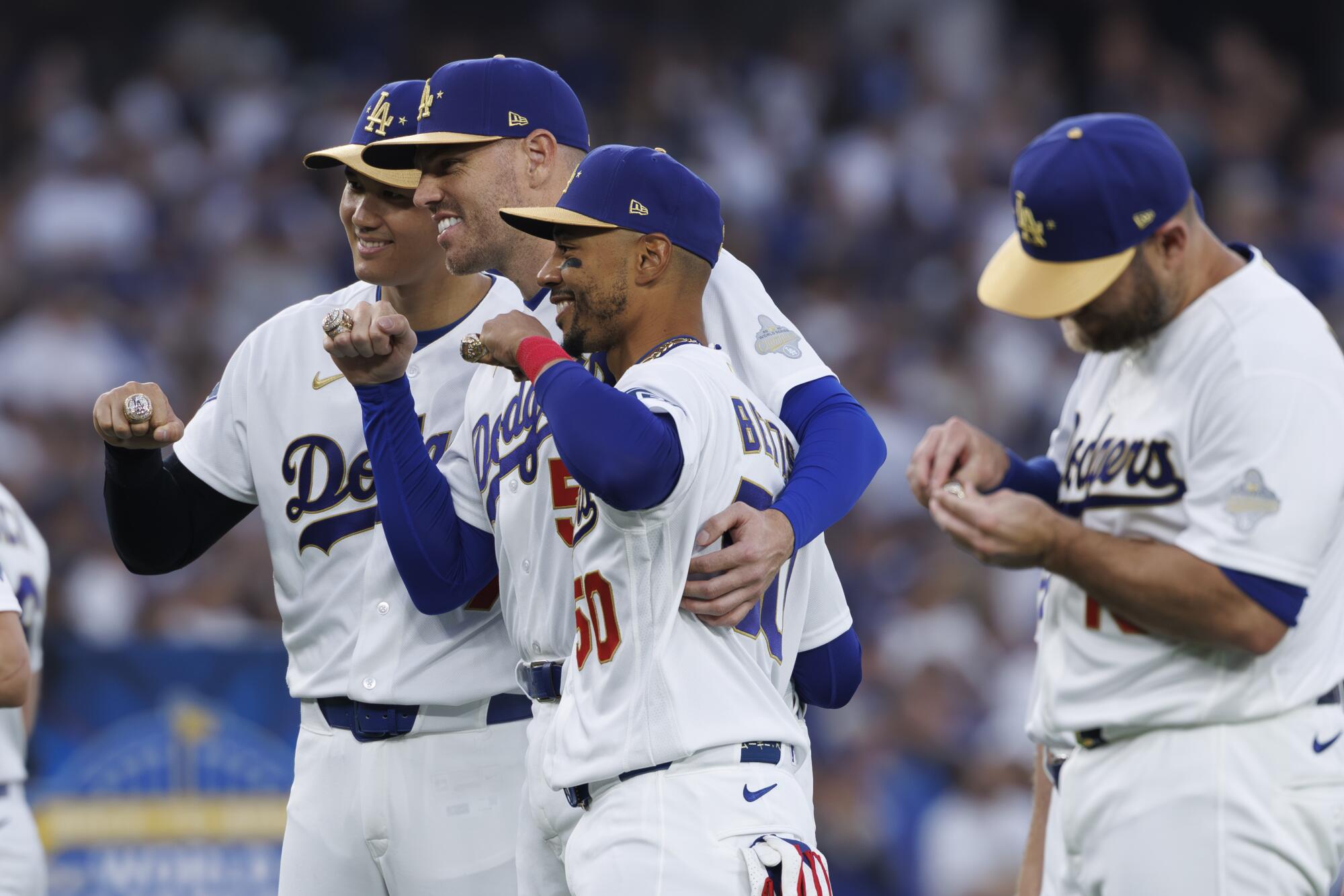 Dodgers players (from left) Shohei Ohtani, Freddie Freeman, Mookie Betts and Max Muncy show off their World Series rings.