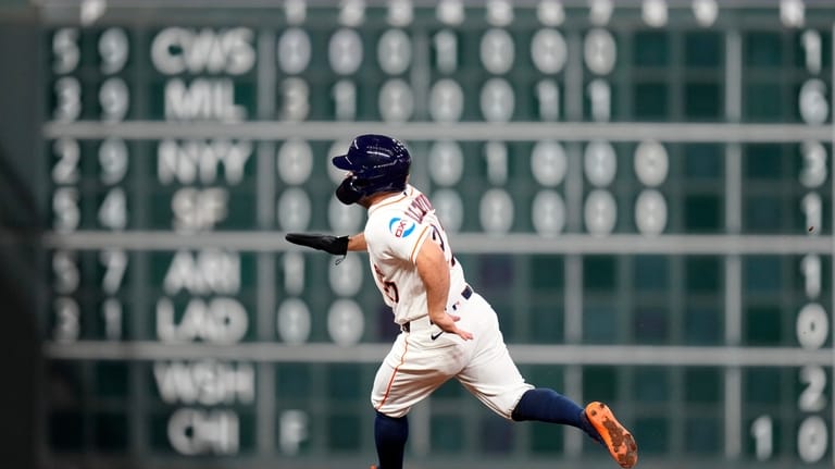 Houston Astros' Jose Altuve runs to third after Yordan Alvarez...