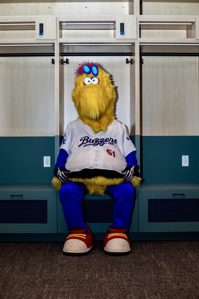A baseball team mascot that looks like a yellow bird in a baseball uniform.
