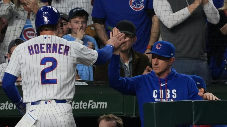 Chicago Cubs' Nico Hoerner (2) is greeted at the dugout...