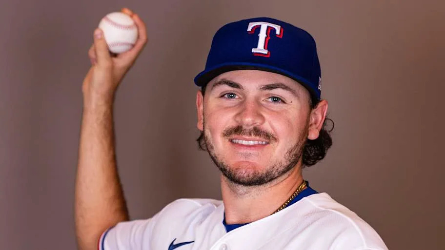 Texas Rangers pitcher Gavin Collyer poses with a baseball during a photo day