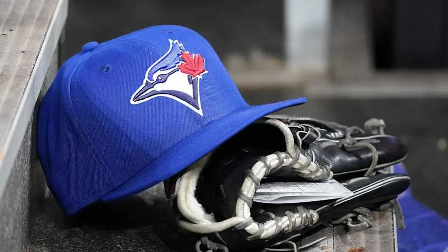 Toronto Blue Jays hat and glove sitting in dugou