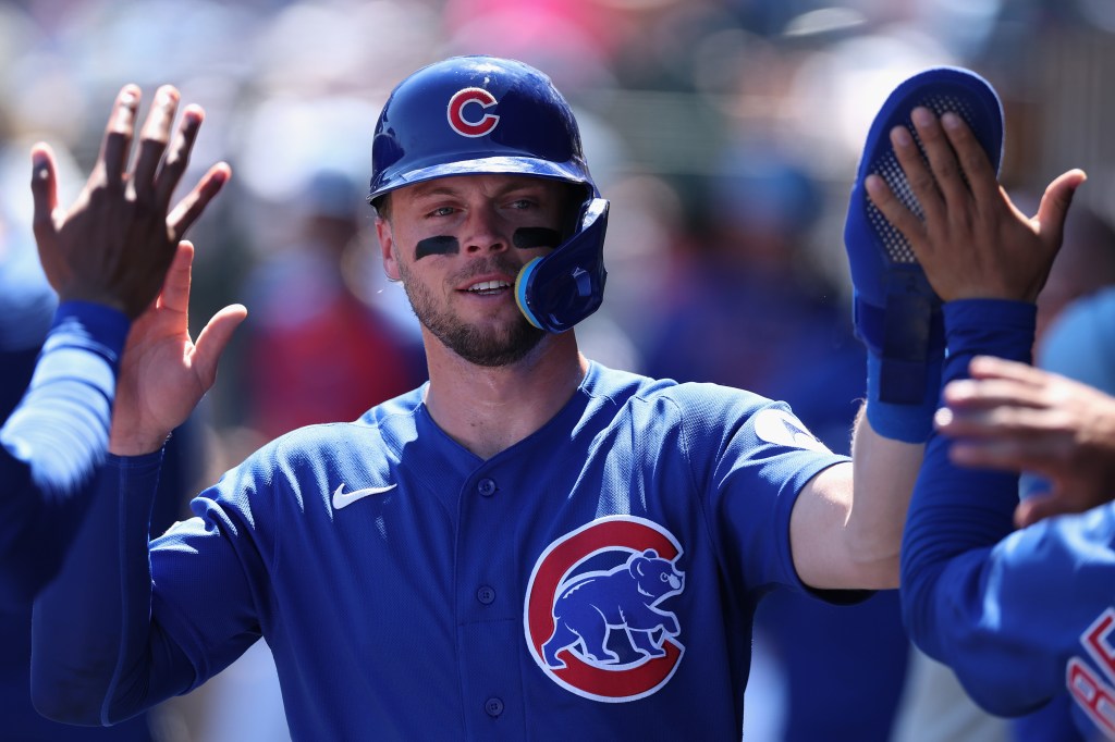 Nico Hoerner high fives teammates after scoring a run.