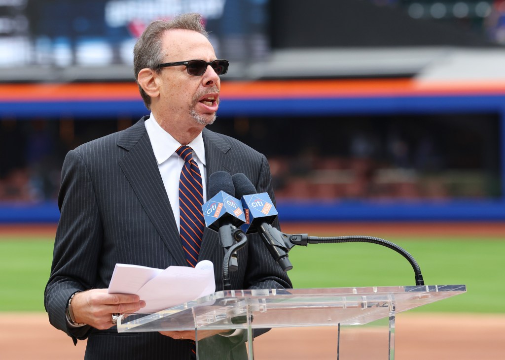 A man in a pinstripe suit and sunglasses speaks at a podium with "Citi Field" branded microphones.