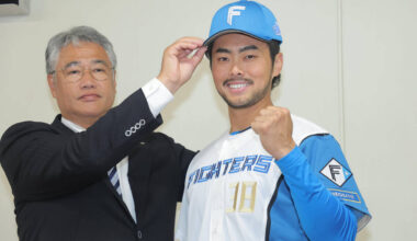 Taiwanese representative Lin Chia-Cheng, whose signing with Nippon-Ham has been confirmed, has his cap placed on his head by acting GM Masao Kida (left) (Photo by Shohei Uemura)