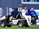 Blue Jays pitcher Cody Ponce is carted off the field with an injury in a break in play against the Colorado Rockies during the third inning at the Rogers Centre on March 30, 2026 in Toronto. 