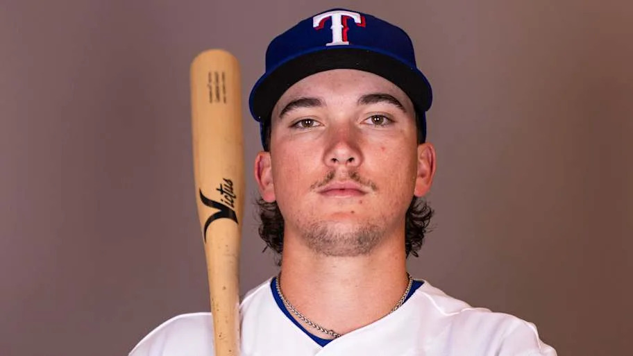 Texas Rangers infielder Cameron Cauley poses for a photo with a bat on his shoulder.