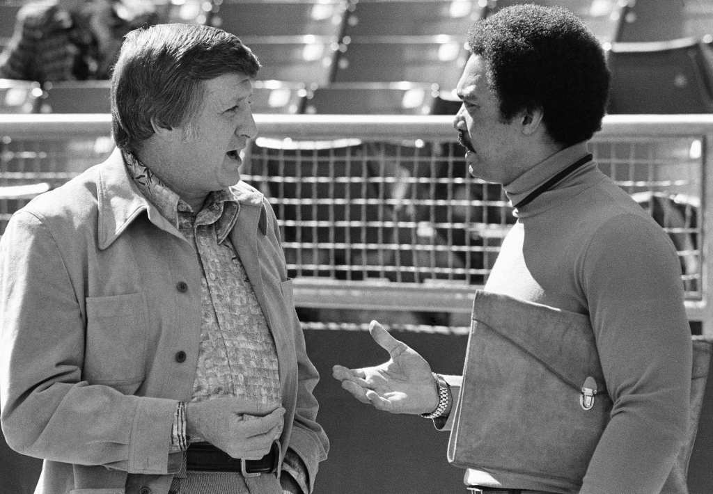 This Oct. 8, 1976 , file photo shows George Steinbrenner, left, principal owner of the New York Yankees, chatting with Reggie Jackson, now a free agent, at Royals Stadium in Kansas City. AP