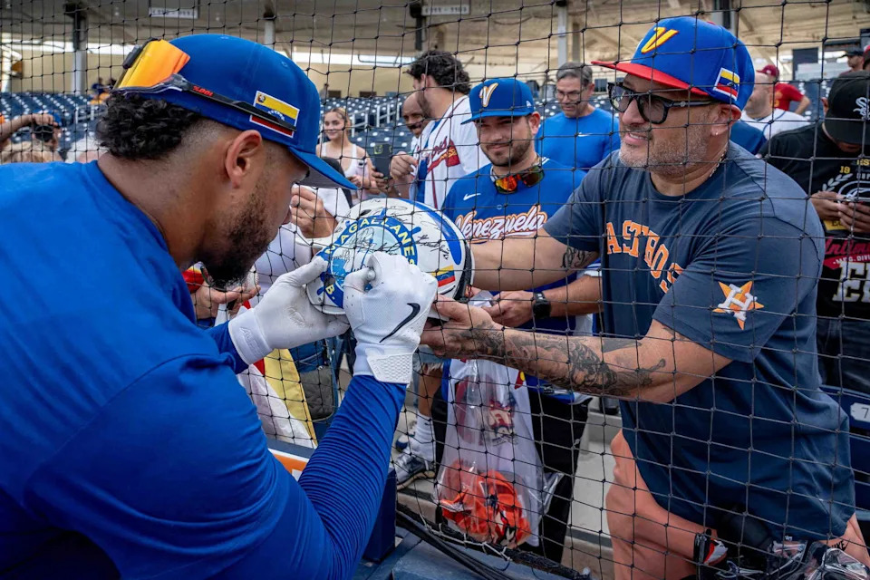 Willson Contreras signs a helmet for Oscar Mayeites before the Venezuela national baseball team played the Houston Astros in an exhibition game during the World Baseball Classic at CACTI Park of the Palm Beaches in West Palm Beach, Fla., on March 4, 2026. Astros won the game 3-1. (THOMAS CORDY/PALM BEACH POST/USA TODAY NETWORK/Imagn Images)