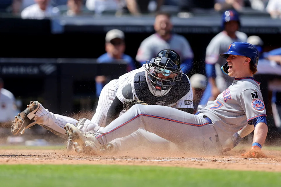 New York Yankees catcher J.C. Escarra (25) tags out New York Mets third baseman Brett Baty (7) trying to score on a double by Mets center fielder Tyrone Taylor (not pictured) during the seventh inning at Yankee Stadium.